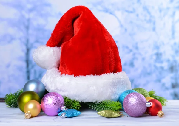 Composition with Santa Claus red hat and Christmas decorations on light background — Stock Photo, Image