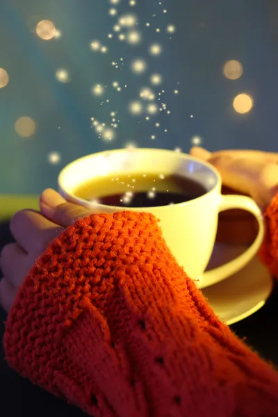 Hände halten Becher mit Heißgetränk, Nahaufnahme, auf hellem Hintergrund — Stockfoto