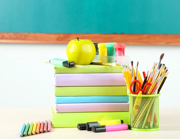 Material escolar en la mesa sobre fondo pizarra — Foto de Stock