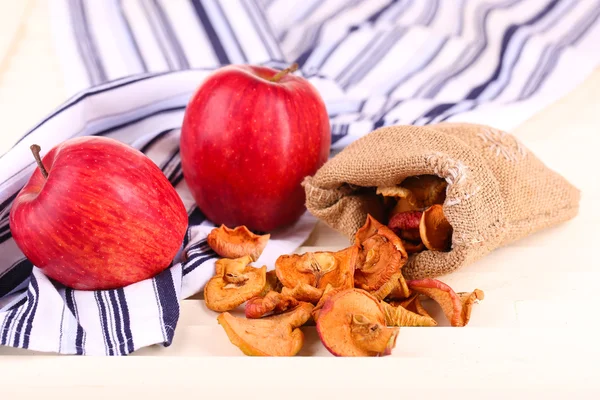 Manzanas secas y manzanas frescas, sobre fondo de madera blanca — Foto de Stock