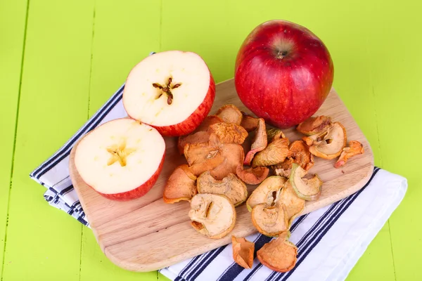 Gedroogde appels, op snijplank, op een houten achtergrond kleur — Stockfoto