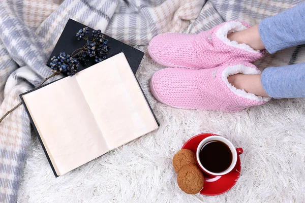 Composition with warm plaid, book, cup of hot drink and female legs, on color carpet background — Stock Photo, Image