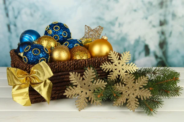 Decorações de Natal em cesta e ramos de abeto na mesa em fundo brilhante — Fotografia de Stock