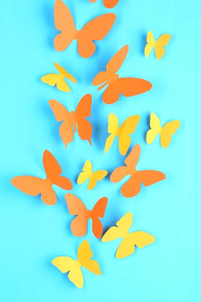 青色の木製ボードの背景に紙蝶 — ストック写真
