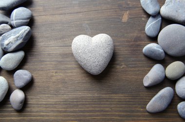 ahşap zemin üzerinde kalp şeklinde gri taş