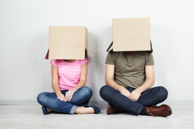 karton kutular üzerinde başlarını duvara yakın katta oturan Çift