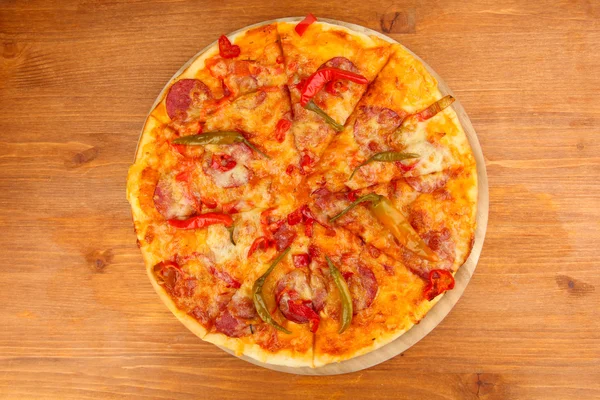 Pizza pepperoni savoureuse sur panneau en bois sur fond en bois — Photo