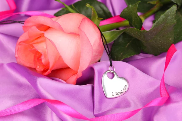 Belle rose rose avec pendentif coeur — Photo