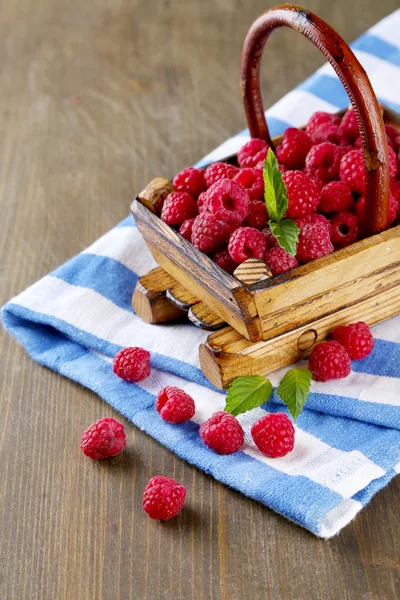 Maturare lamponi dolci in cesto su sfondo di legno — Foto Stock