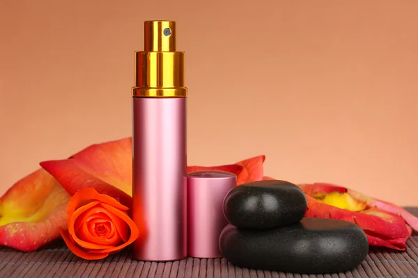 Women's perfume in beautiful bottle with rose on brown background — Stock Photo, Image