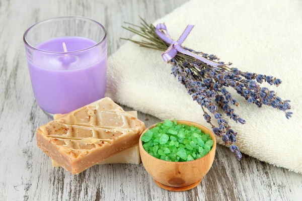 Asetelma laventeli kynttilä, saippua, saippua ja tuore laventeli, puinen tausta — kuvapankkivalokuva