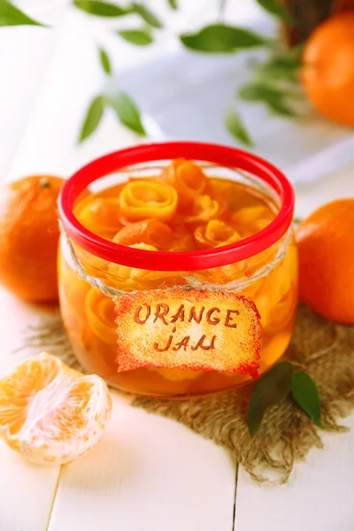 Orangenmarmelade mit Schale und Mandarinen, auf weißem Holztisch — Stockfoto