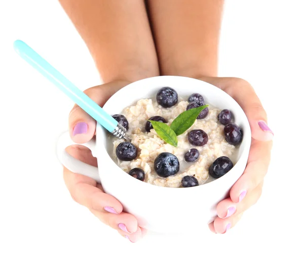 Harina de avena en taza con bayas en las manos aisladas en blanco — Foto de Stock