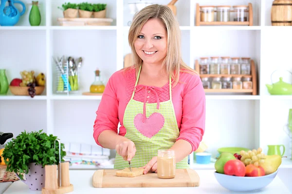 Boldog mosolygó nő a konyhában készül szendvics — Stock Fotó