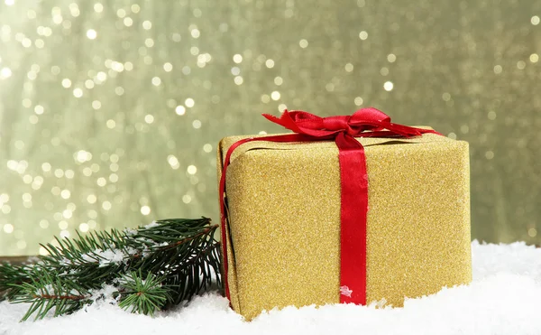 Szép fényes ajándék és a karácsonyfa, fényes háttéren — Stock Fotó