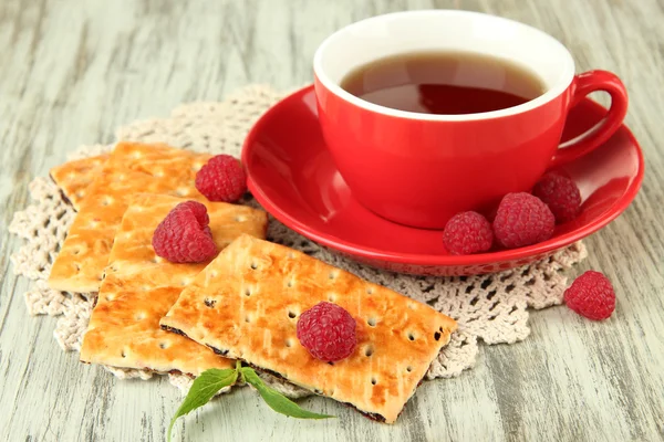 Kopje thee met koekjes en frambozen op tabel close-up — Stockfoto