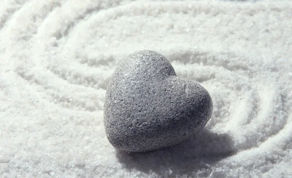 Gris piedra zen en forma de corazón, sobre fondo de arena — Foto de Stock