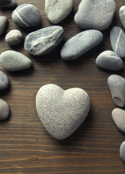 Grey stone in shape of heart, on wooden background — Stock Photo, Image