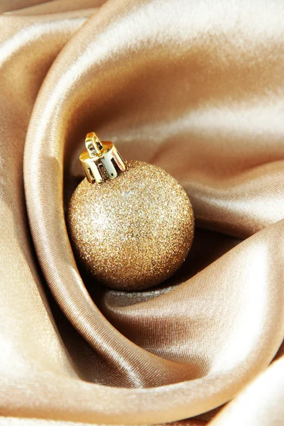 Beautiful Christmas ball on golden satin cloth — Stock Photo, Image