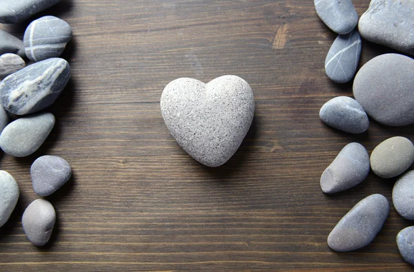 ahşap zemin üzerinde kalp şeklinde gri taş