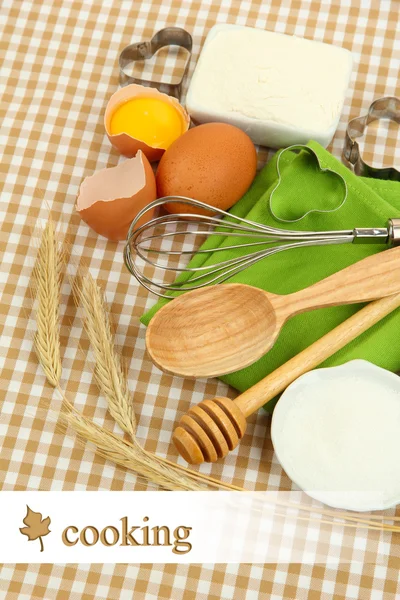 Kochkonzept. Grundlegende Backzutaten und Küchengeräte auf Tischdecken-Hintergrund — Stockfoto