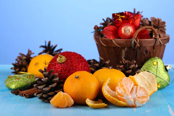 Christmas composition with tangerines on wooden table on blue background — Stock Photo, Image