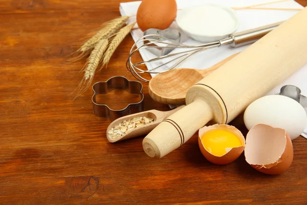 Conceito de cozinha. Ingredientes básicos de cozimento e utensílios de cozinha na mesa de madeira — Fotografia de Stock