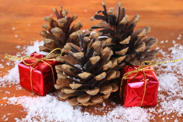 Kerstversiering met dennenappels op houten achtergrond — Stockfoto