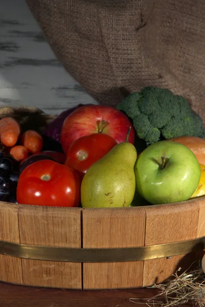 Composição de diferentes frutas e legumes na mesa sobre fundo de pano de saco — Fotografia de Stock