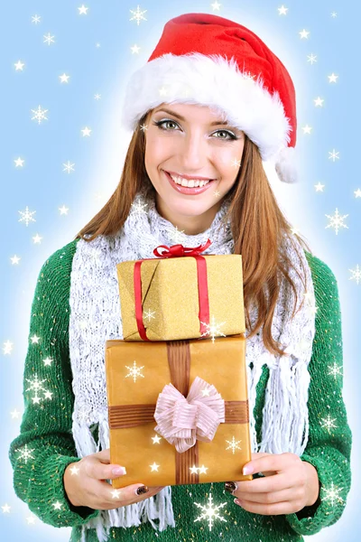 Schöne lächelnde Mädchen in New Year Hut mit Geschenken isoliert auf weiß — Stockfoto