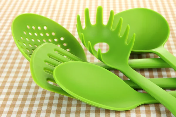 Plastic kitchen utensils on fabric background