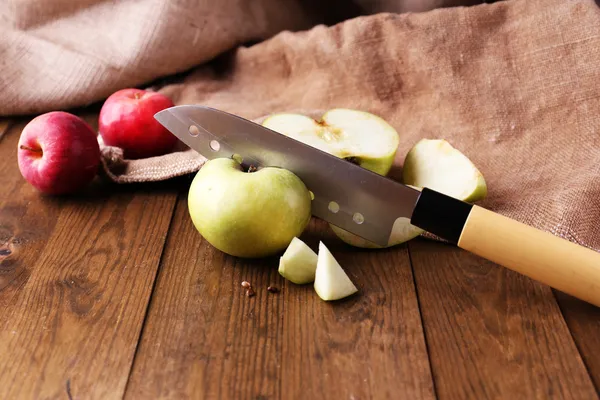 Faca de cozinha e maçãs, sobre fundo de madeira — Fotografia de Stock
