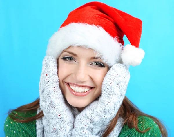 Hermosa chica sonriente en sombrero de Año Nuevo sobre fondo azul —  Fotos de Stock