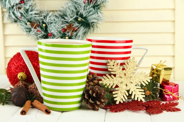 Copas de cacao caliente con chocolates y decoraciones de Navidad en la mesa sobre fondo de madera —  Fotos de Stock
