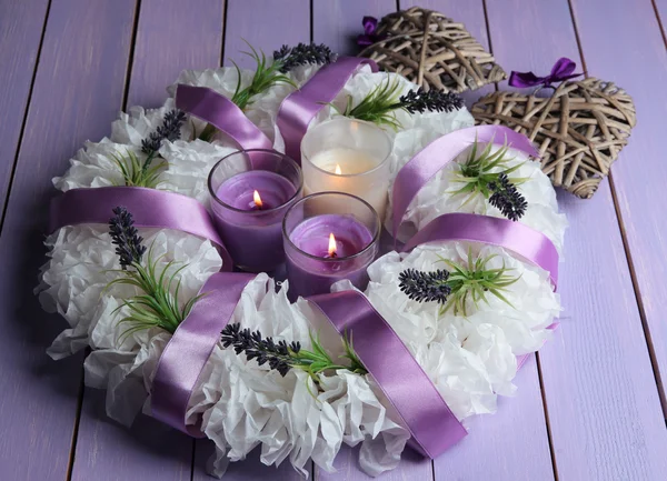 Dekorativer Kranz mit Kerzen auf Holzgrund — Stockfoto
