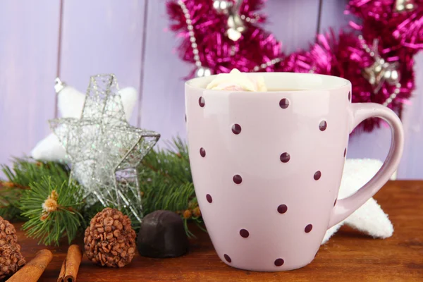 Cup of hot cacao with chocolates and Christmas decorations on table on wooden background — Stock Photo, Image