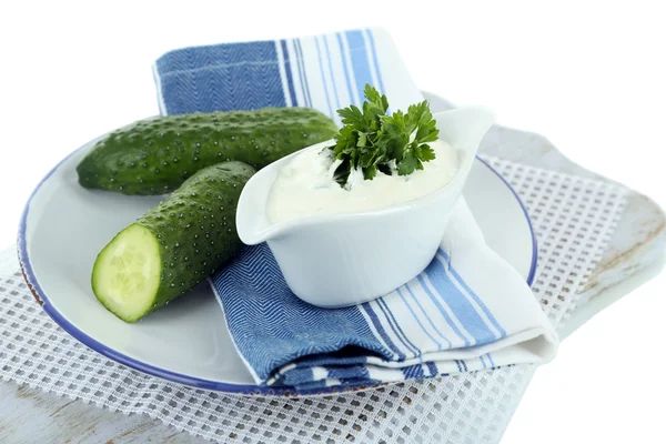 Gurka yoghurt i sauceboat, på färg Servett, isolerad på vit — Stockfoto