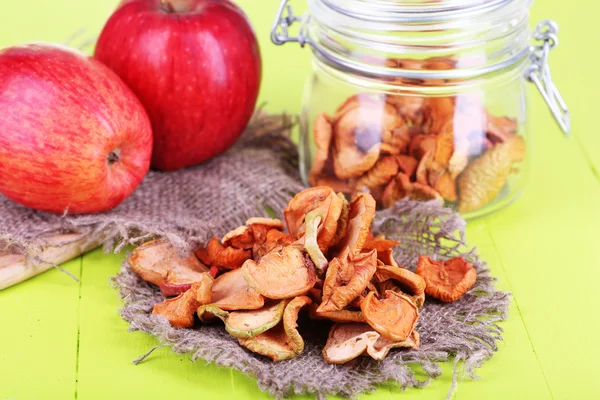 Gedroogde appels in glazen pot, op een houten achtergrond kleur — Stockfoto