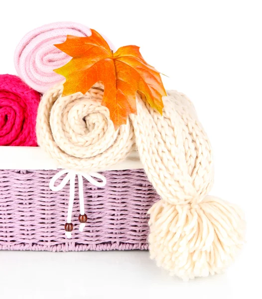 Warm knitted scarves in basket isolated on white — Stock Photo, Image