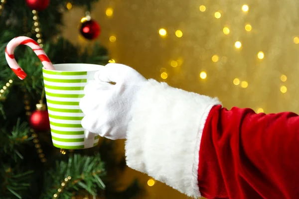 Santa holding mug in his hand, on bright background — Stock Photo, Image