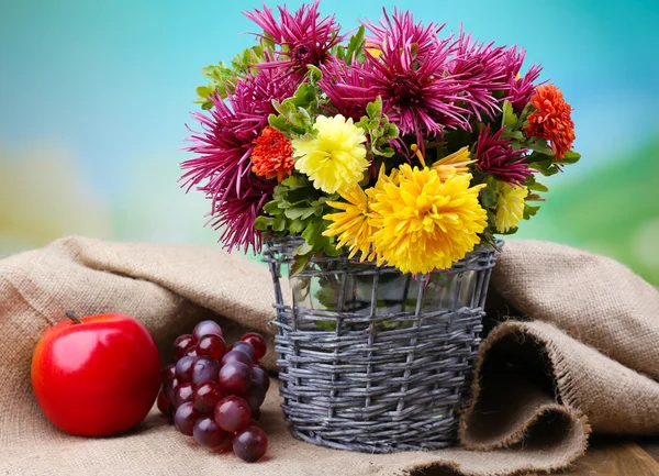 枝編み細工品の花瓶とフルーツ、明るい背景に美しい花の組成 — ストック写真