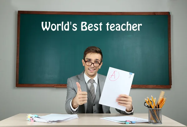 Young teacher sitting in school classroom — Stock Photo, Image