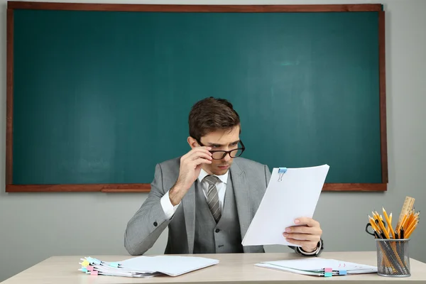 Junge Lehrerin sitzt im Klassenzimmer — Stockfoto