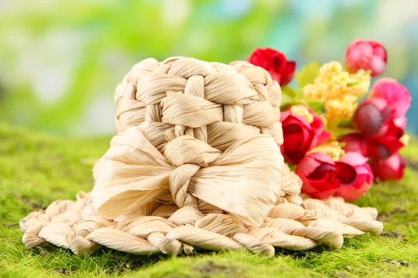 Small straw hat with flowers, on green moss — Stock Photo, Image