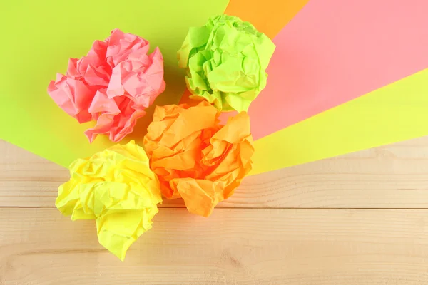 Colorful crumpled paper balls on wooden background — Stock Photo, Image