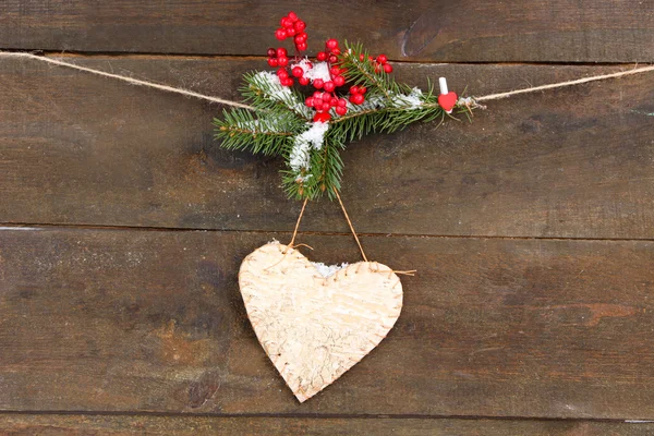 Cuore decorativo su corda, su sfondo di legno — Foto Stock