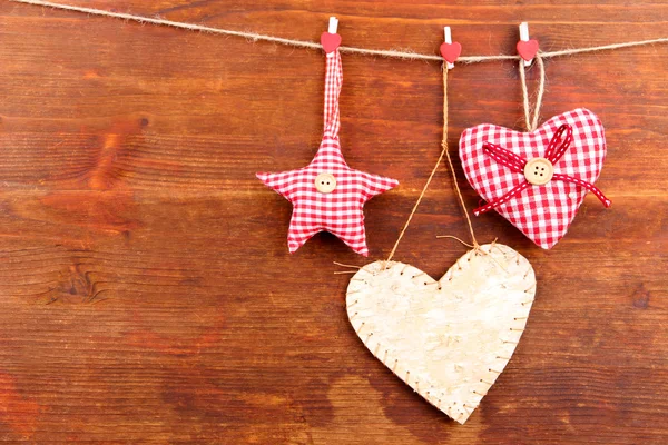 Decorative heart and star on rope, on wooden background — Stock Photo, Image