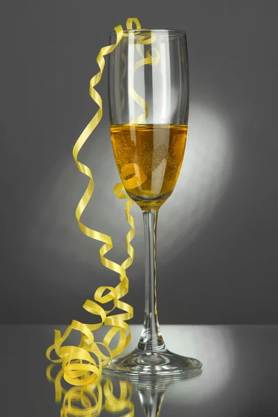 Glas champagne och streamer efterfest på grå bakgrund — Stockfoto