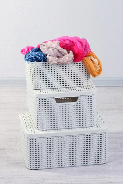 Plastic baskets with things in floor on room background — Stock Photo, Image