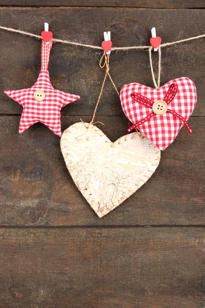 Coeurs décoratifs et étoile sur corde, sur fond de bois — Photo